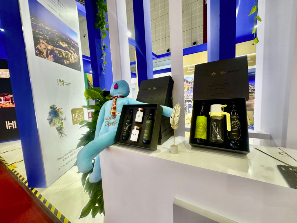 Elaion olive oil and Melariston honey gift sets displayed at the Hellas Group booth during CIIE, showcasing premium Greek food products.