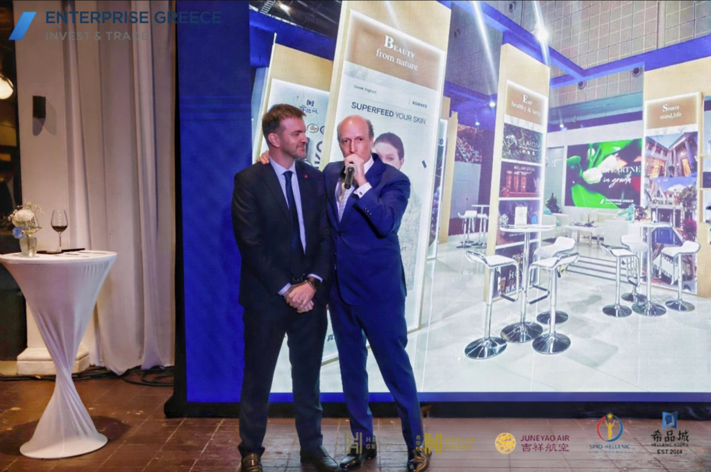Enterprise Greece reception at Hellas House during CIIE in Shanghai, featuring a keynote speech with the “The Best of Greece” showcase displayed behind.